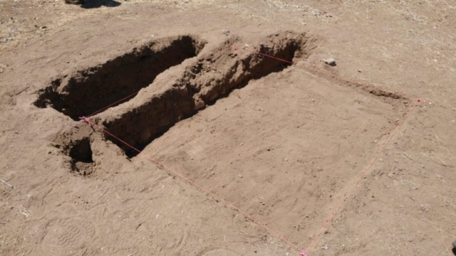 The excavation unit Chris is working in. Note the adobe wall the unit extends from.