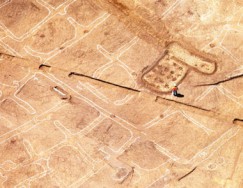 An archaeologist with Desert Archaeology, Inc., examines a re-created field area within the roughly 3,000-year-old expanse of irrigation canals and bordered fields currently under excavation at Las Capas in the Tucson Basin. More than fifteen acres of fields were once present.