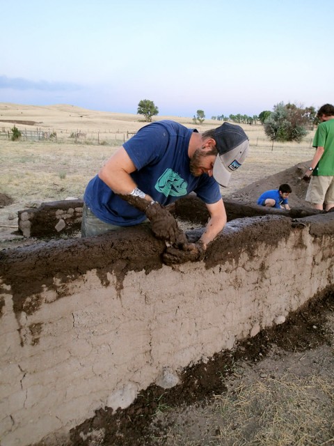 Aaron, Riley, and Max add puddled adobe to our experimental adobe room walls. Photo by Allen Denoyer.