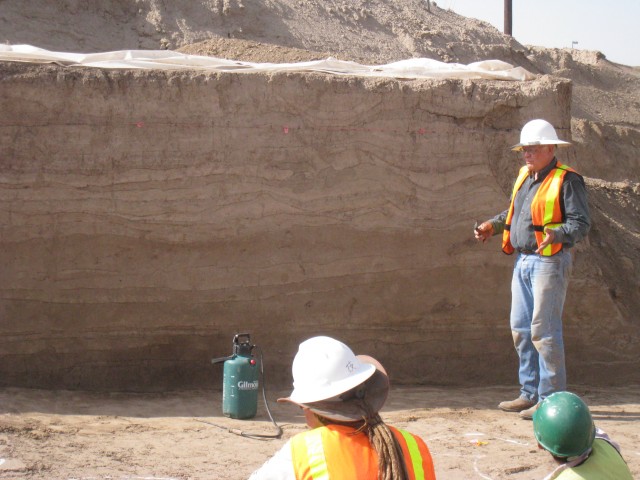 Fred Nials points out flood-deposited sediments covering canals at the Las Capas site in northwest Tucson. Each of these layers represent sediments deposited in major floods when watercourses overflowed their banks. Between about 1000 and 900 B.C., irrigation canals at Las Capas were covered by a thick layer of sediment, probably damaged by a massive flood that ultimately may have caused people to abandon the settlement.