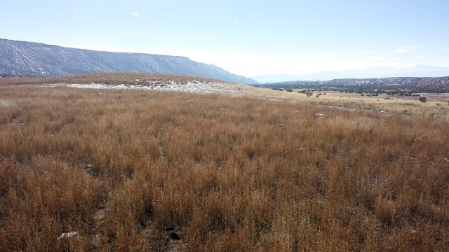View to the south of the massive village of Ponsip Akeri on a terrace above the Rio Ojo Caliente. This site was probably the largest pueblo ever constructed in the area, with perhaps 2,000 rooms.