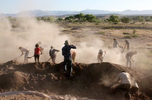 It’s a dirty job, but somebody’s got to do it. These archaeologists are backfilling excavation units–placing a protective barrier layer (usually clean sand) to show that they worked there, and then filling the unit with dirt.