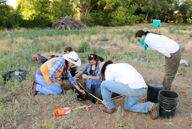 Leslie helps Patrick, Elissa, Connor, and Lindsay measure with a plumb bob.