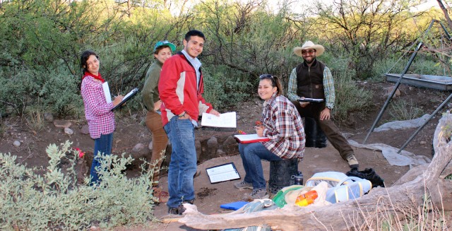 Lara, Katie J., Daniel, Carrie, and Lewis discuss paperwork in their excavation unit.