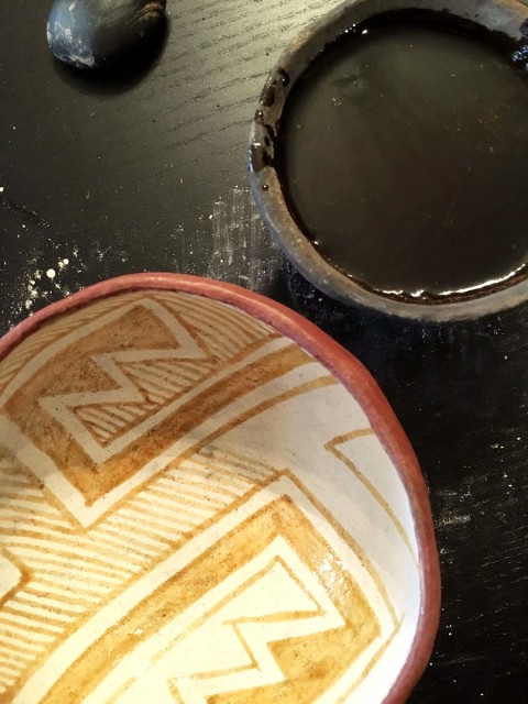 A Pinto Polychrome bowl in the process of being painted with yucca fruit (organic) paint.