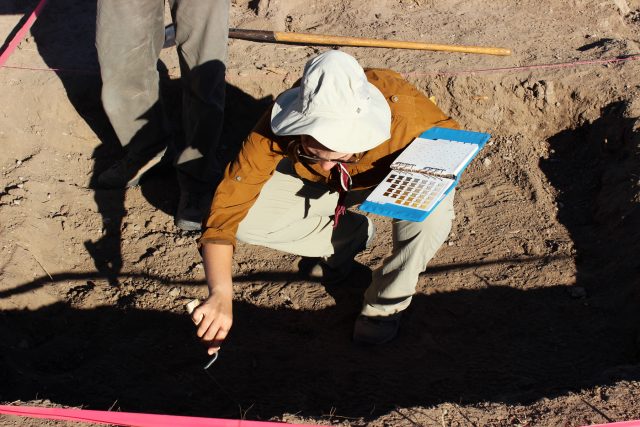 Madisen learns to use a Munsell color chart during our 2014 Preservation Archaeology Field School. These charts aim to reduce bias by standardizing the way we record soil color changes as we excavate.