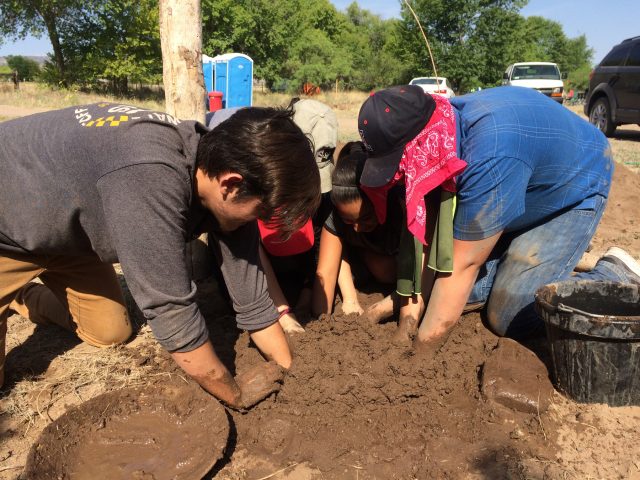 Students from Linking Hispanic Heritage through Archaeology (LHHTA) group from Tucson mixing mud. How many hands can you fit into a mud pit?