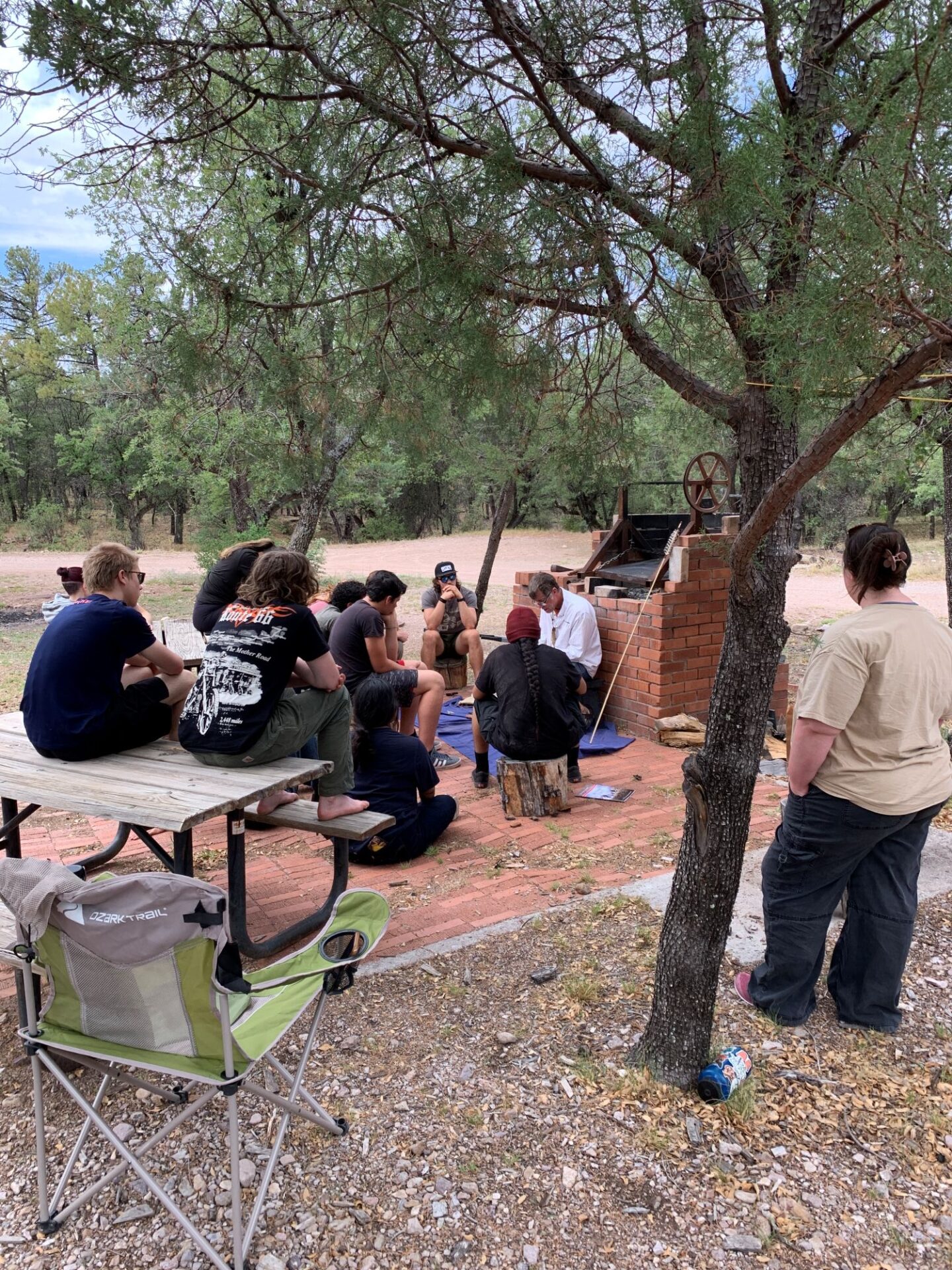Sara looks on as Allen demonstrates flintknapping to the Wild AZ Youth Conservation Corps in 2024.