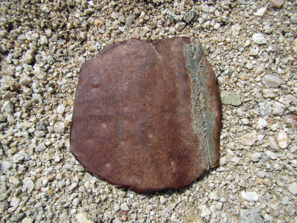 Flat metal piece that was cut from a container with a crimped and soldered seam, possibly a fuel container. It likely dates to the ranching era prior to park establishment. It was an isolated artifact on the ground surface.