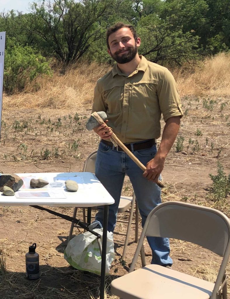 Student holds stone axe he made.