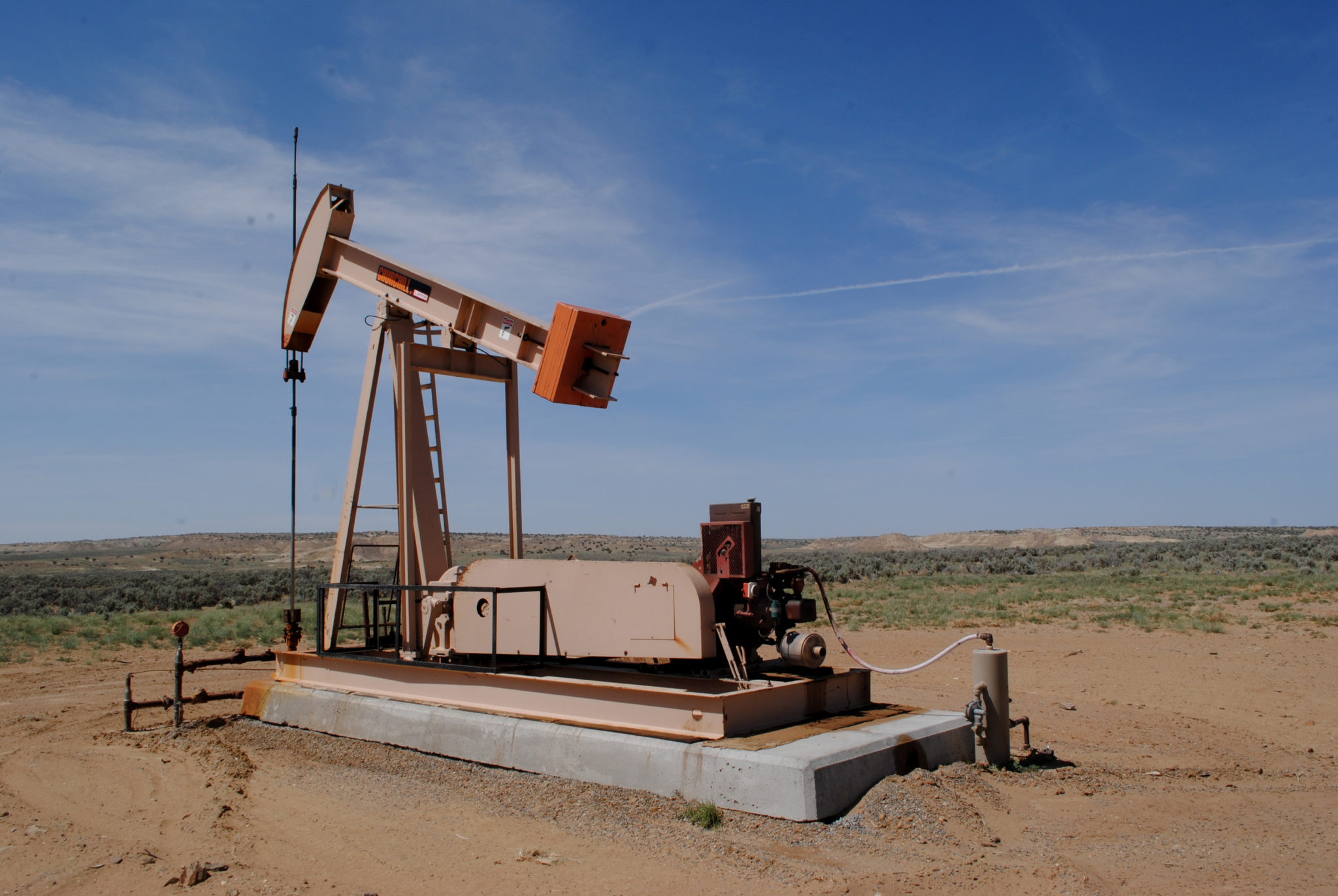 Pump jack near Pierre’s site, which is on the hill in the background. Image courtesy of EcoFlight.