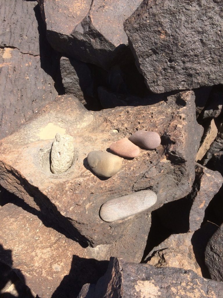 A boulder mortar and associated toolkit found in situ near petroglyphs along the lower Gila River.