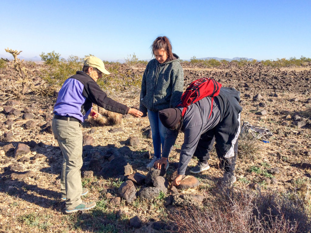 Volunteer Fran Mauiri (left) assists Keija Koteen (center) and Ida Jose (right) with measuring a rock pile.