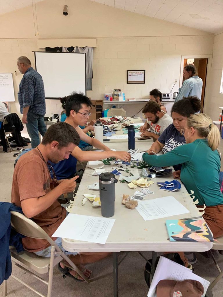 Sam Rosenbaum, Ruijie Yao, Kathrine Taylor, and Gabby Pfleger sort historic artifacts in an analysis exercise with historical archaeology expert Homer Thiel.