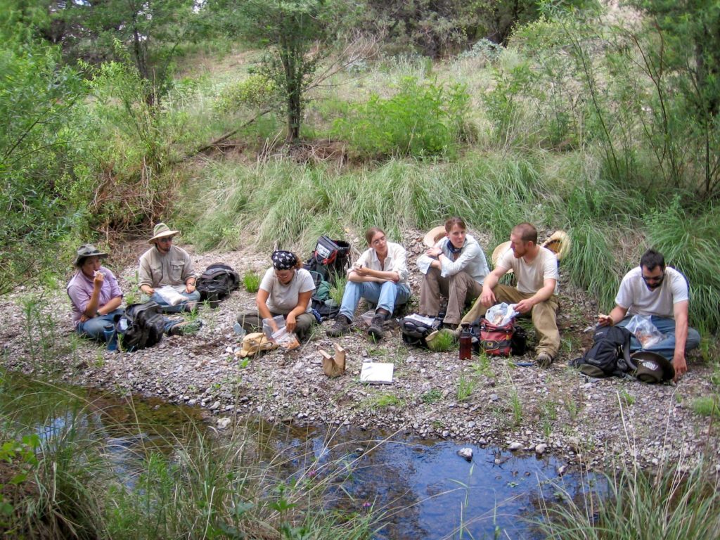 Staff and students of the early field school taking a break. Longtime staff member and current Research Associate Katherine Dungan is at center.