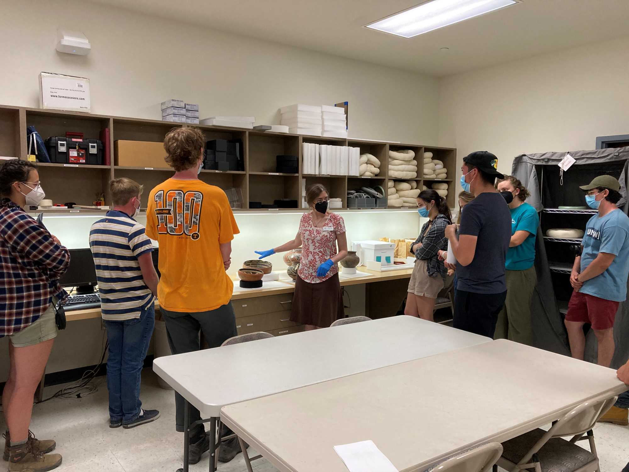 Katherine Dungan (Arizona State Museum) shows students some Salado pottery vessels in the ASM Pottery Vault.