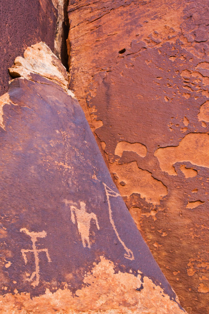 This flute player, duck-headed figure, and other Basketmaker figures are carved on a cliff wall in the former boundaries of the Bears Ears National Monument. © Jonathan Bailey