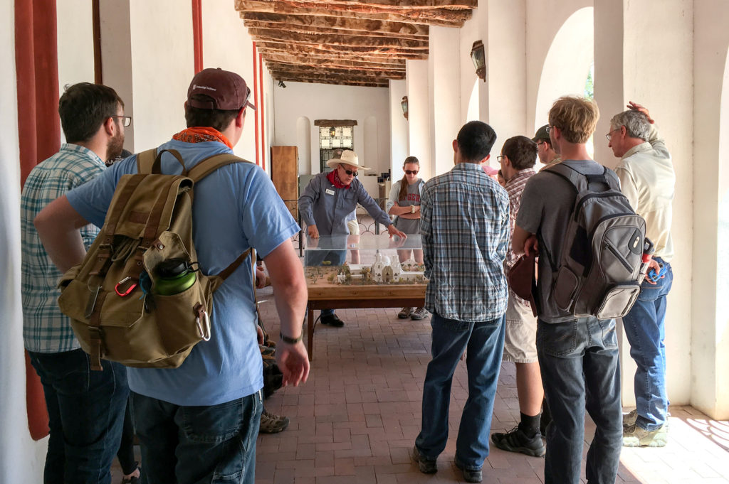 Martín De Soto displaying a model of the San Xavier Mission to field school students. Image: Karen Schollmeyer
