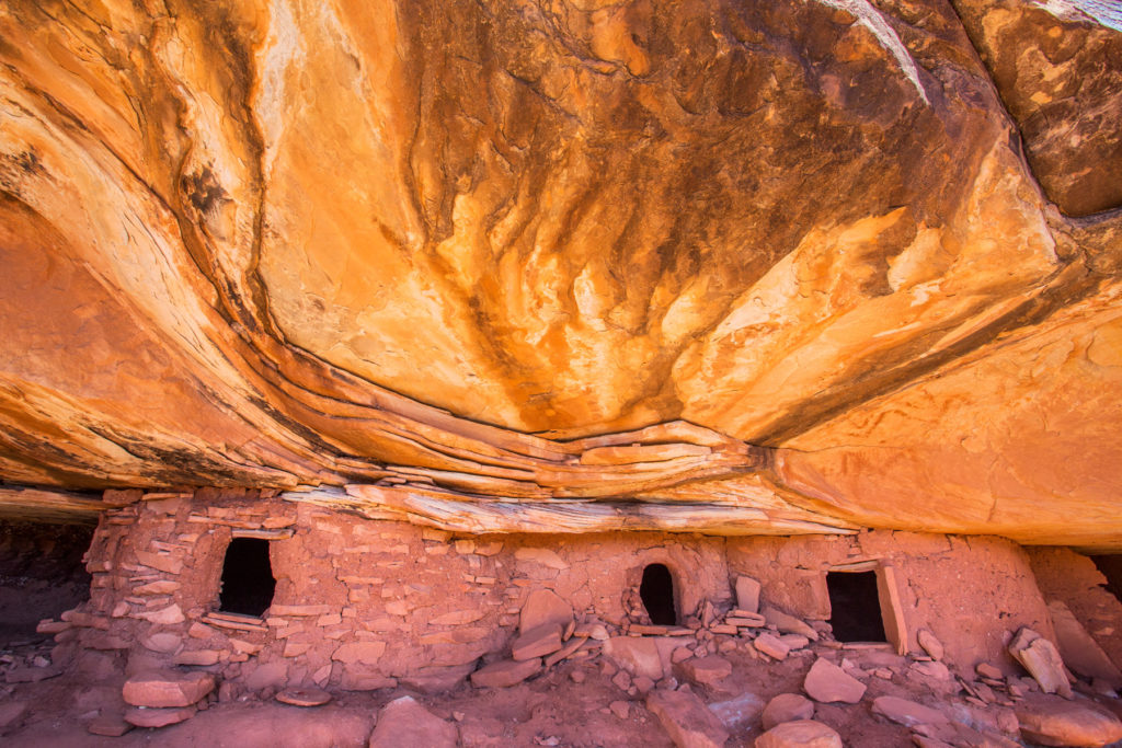 These Ancestral Puebloan structures are shown with beautiful paintings displayed above the far-right door. © Jonathan Bailey