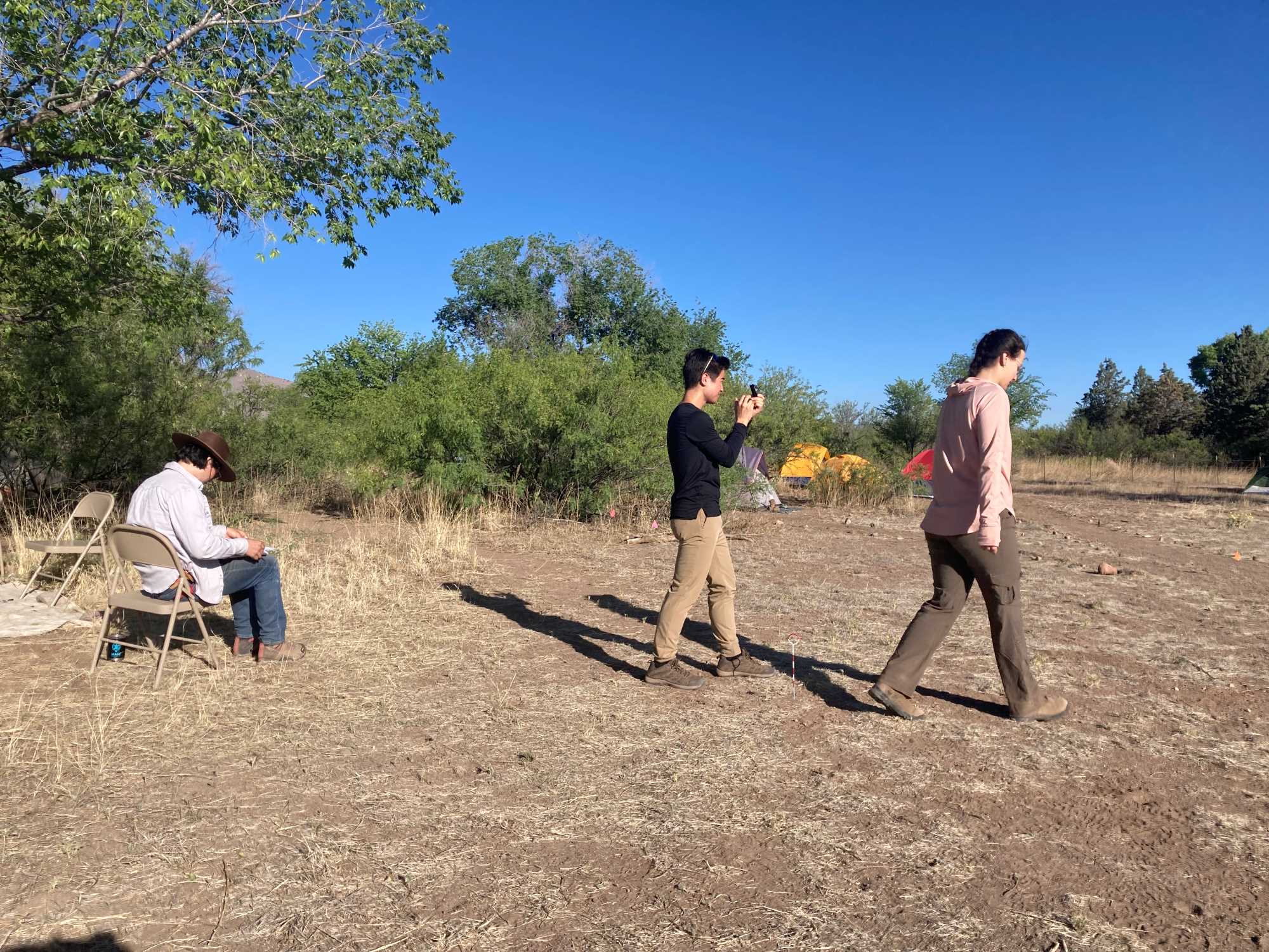 Jorge (left) works on the map as Avy (right) paces her way toward the pump house and I use the compass to approximate the angle for our map.