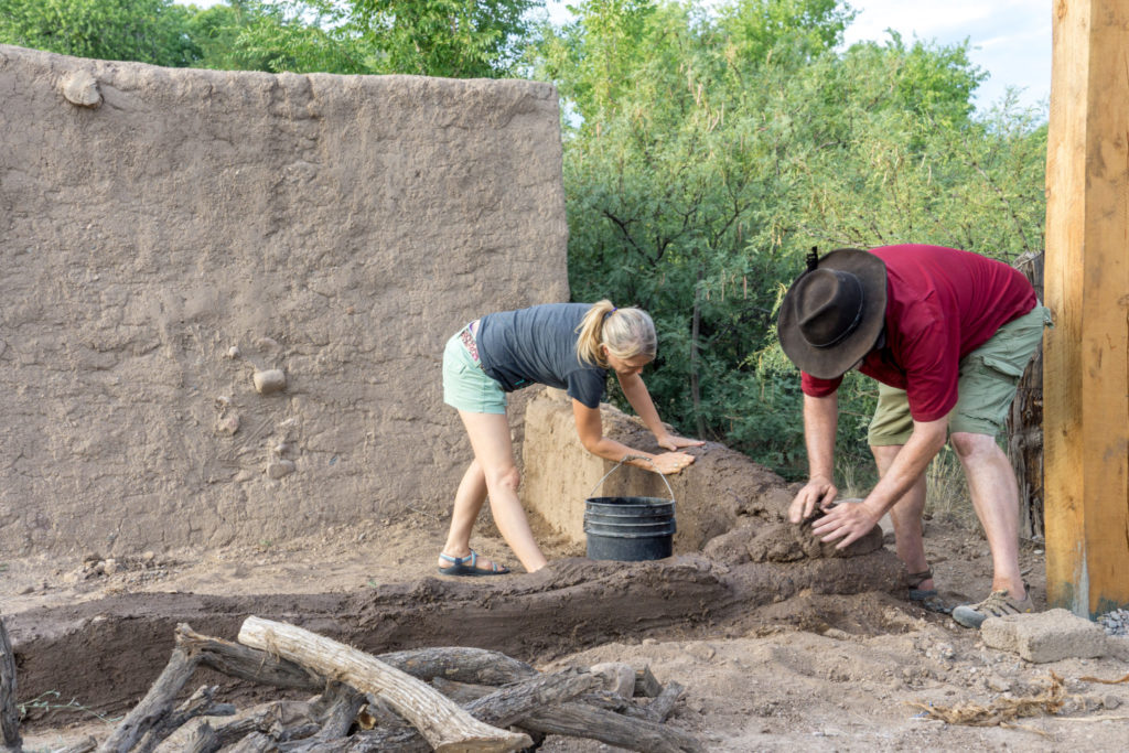 “Mudding” the wall of a new structure using the puddled adobe method. Image: Kathleen Bader