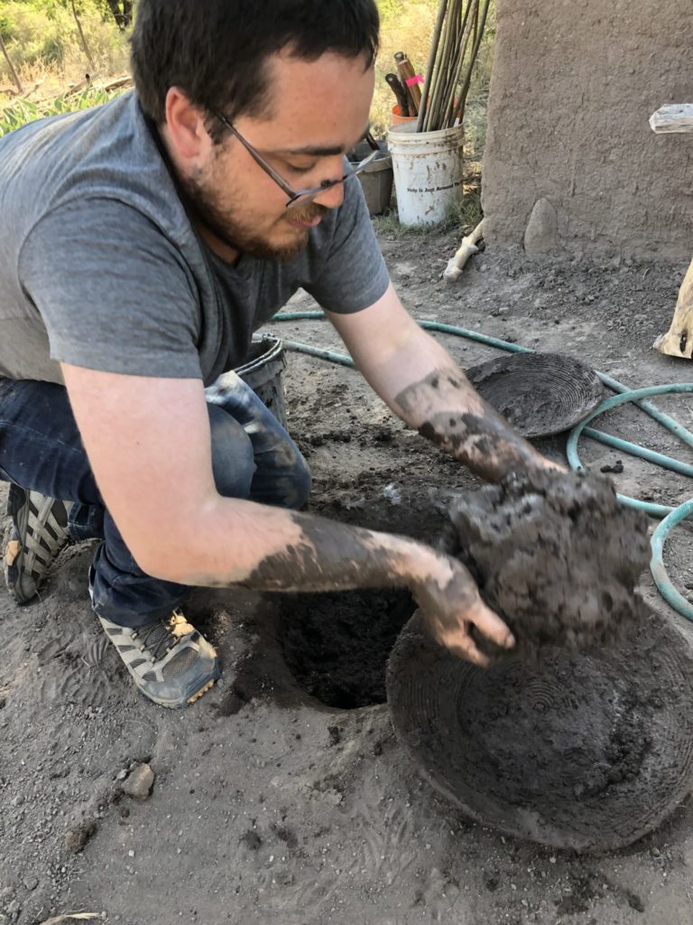 James loading basket with mud