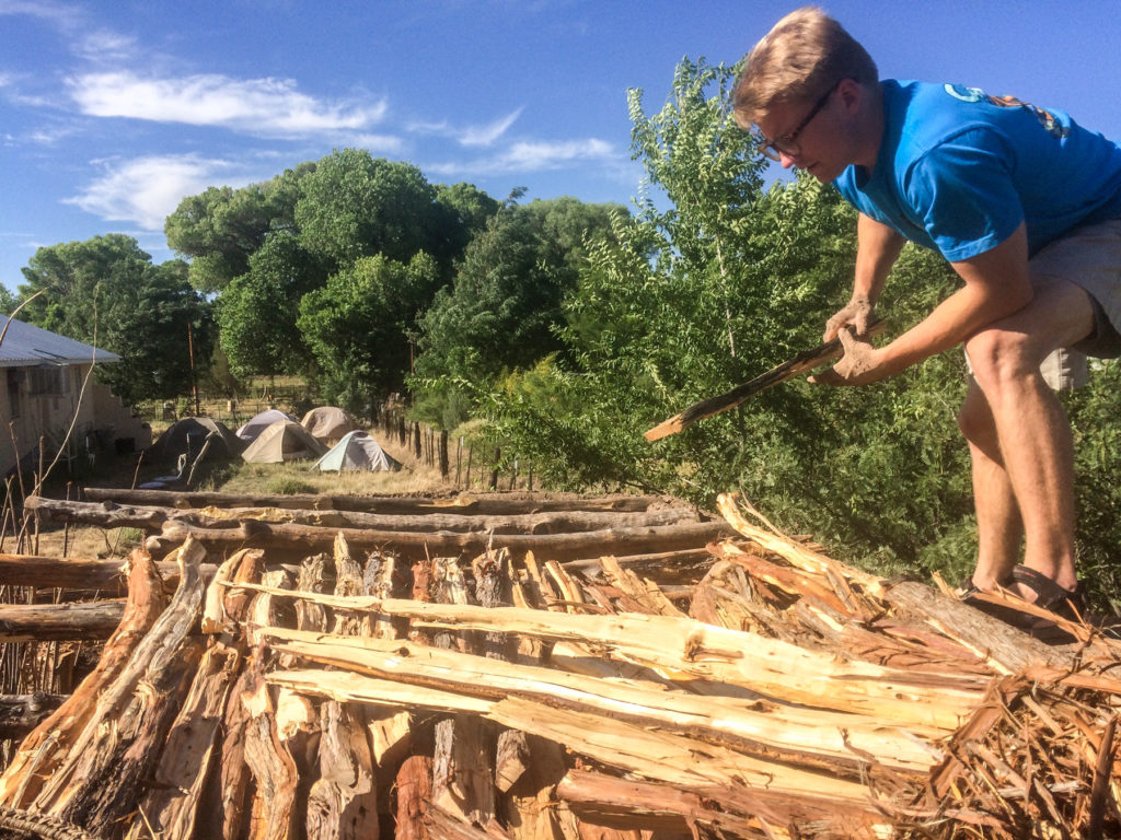 Matt fitting split Juniper beams on to roof