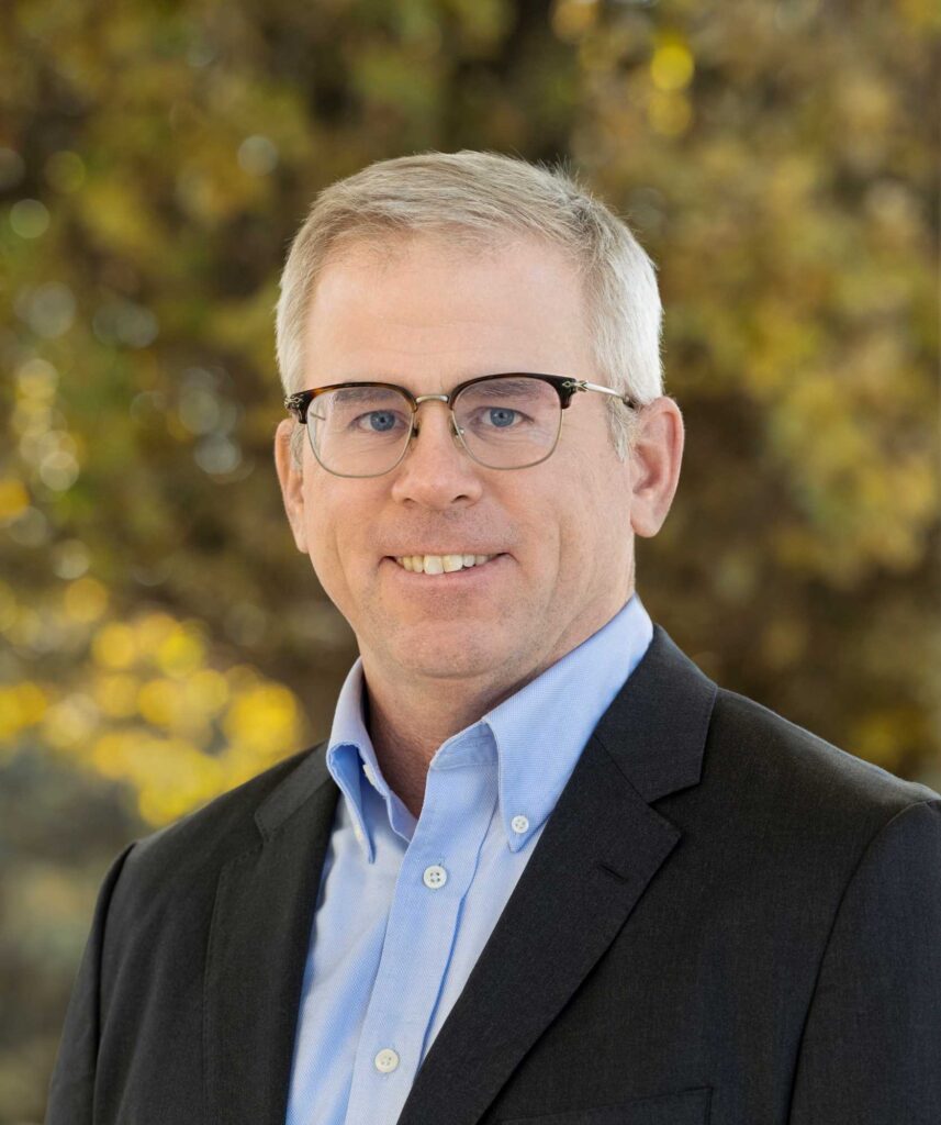 Head shot of a smiling man in a collared shirt and sportcoat. He is the incoming President and CEO.