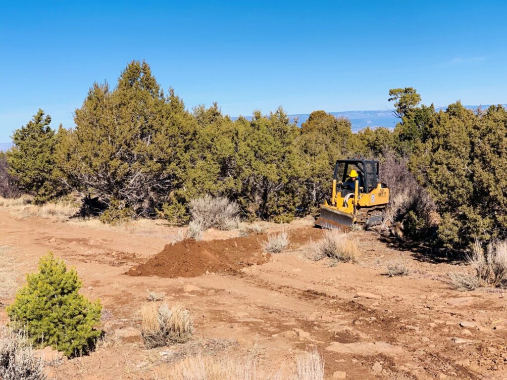 A small bulldozer being used to install a drain on an off-highway vehicle (OHV) trail in Colorado.