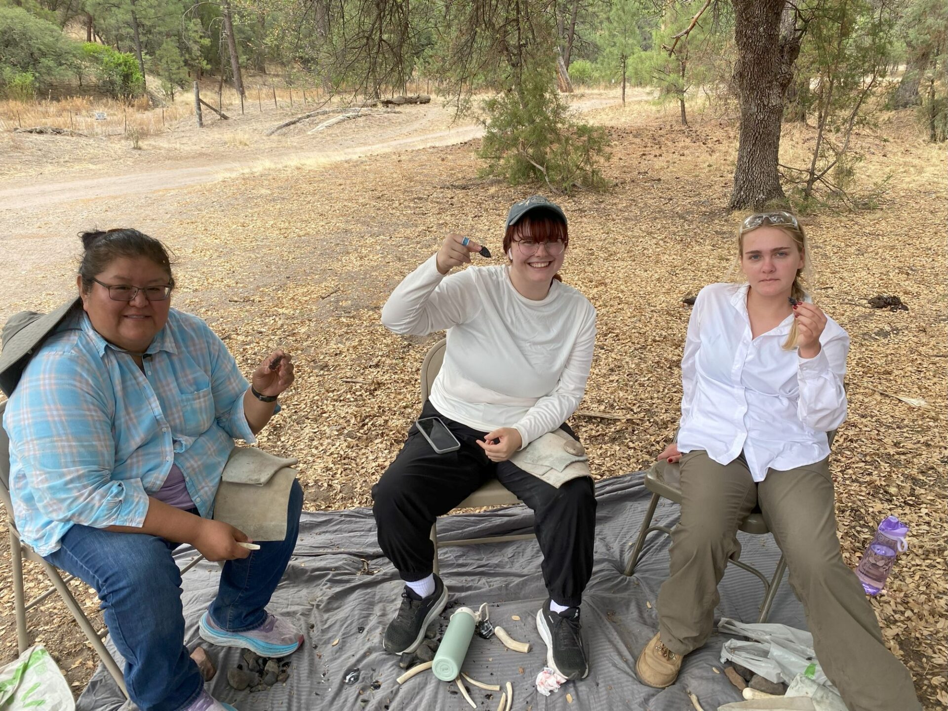 Sonya, Alexis, and Aurelia with the stone knife blades they’re making with Allen.