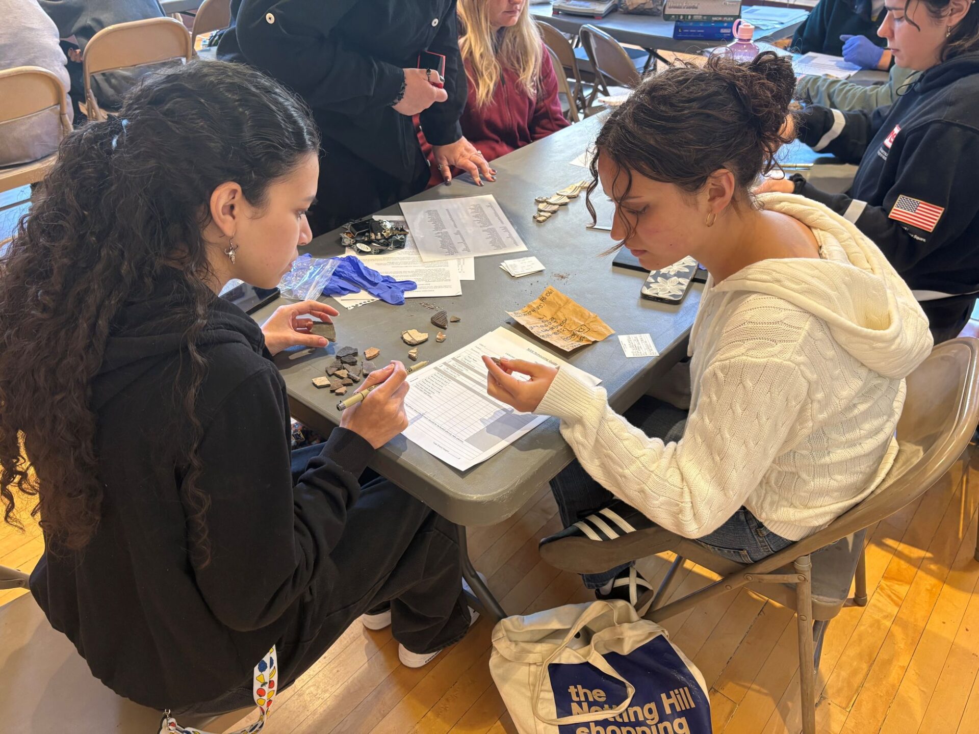 Quetzalli and Carmen analyzing pottery at the WNMU Museum.