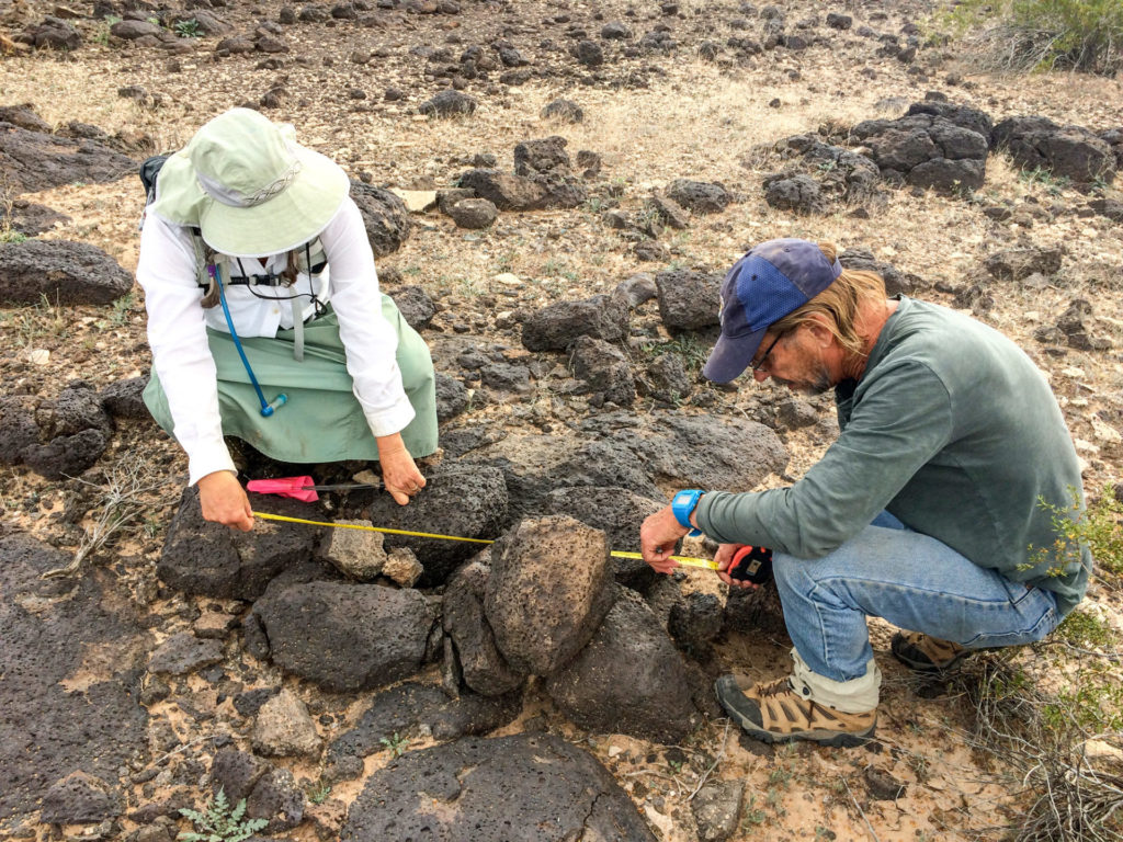 Volunteers Janet Miller (left) and Bruce Hilpert (right) measuring a rock pile.