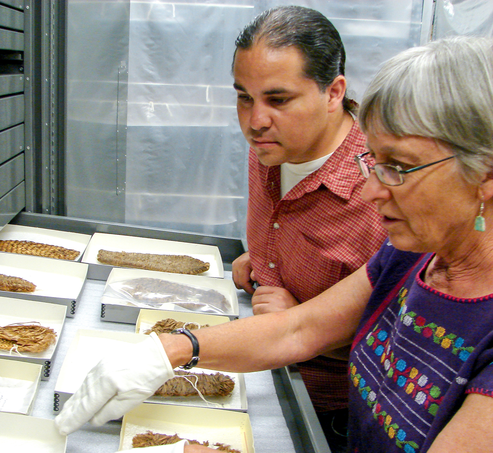 Laurie Webster & Louie Garcia looking at perishable artifacts. Courtesy of Edge of the Cedars State Park Museum.